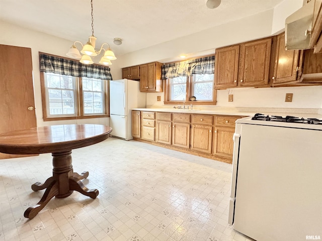 kitchen with pendant lighting, sink, white appliances, a notable chandelier, and ventilation hood