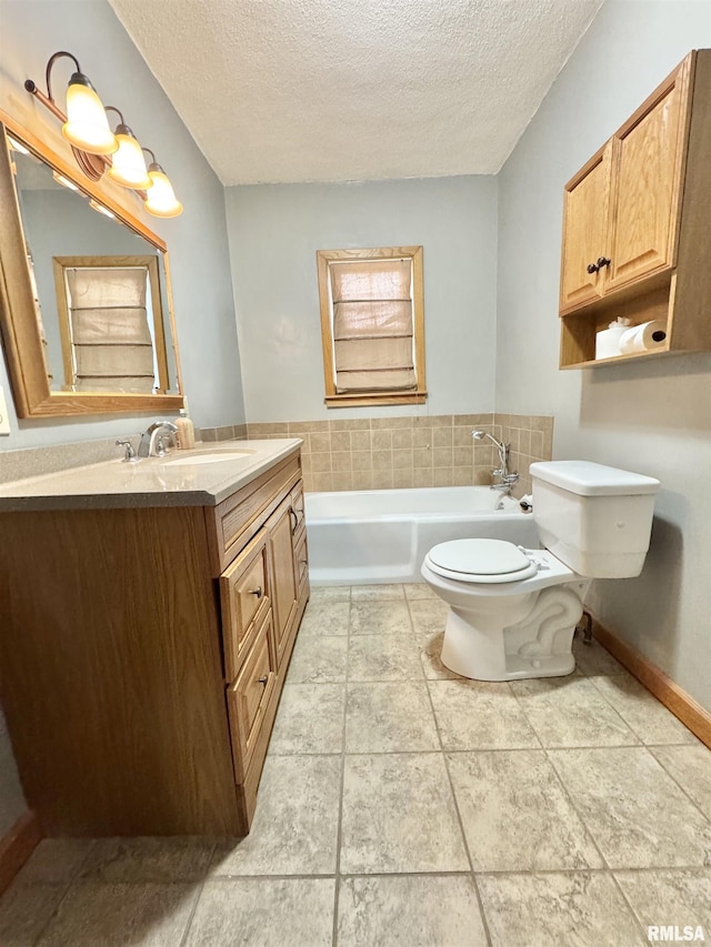 bathroom with toilet, vanity, a textured ceiling, and a tub to relax in