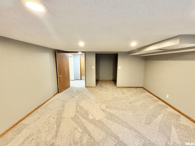 basement with light carpet and a textured ceiling