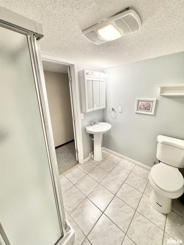 bathroom with tile patterned floors, toilet, an enclosed shower, sink, and a textured ceiling