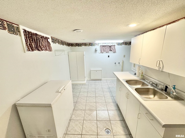 kitchen featuring white cabinetry, sink, and a textured ceiling