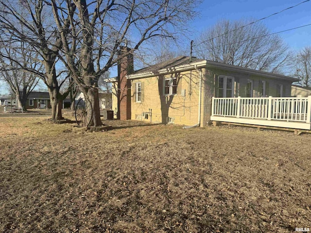 view of home's exterior featuring a wooden deck, a lawn, and central air condition unit