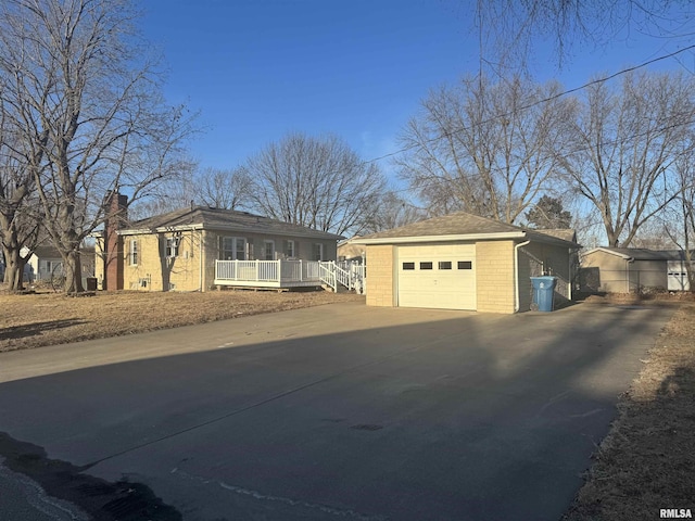 view of property exterior featuring a garage, an outdoor structure, and covered porch