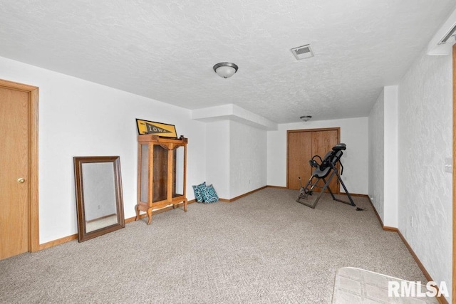 interior space featuring a textured ceiling and carpet flooring