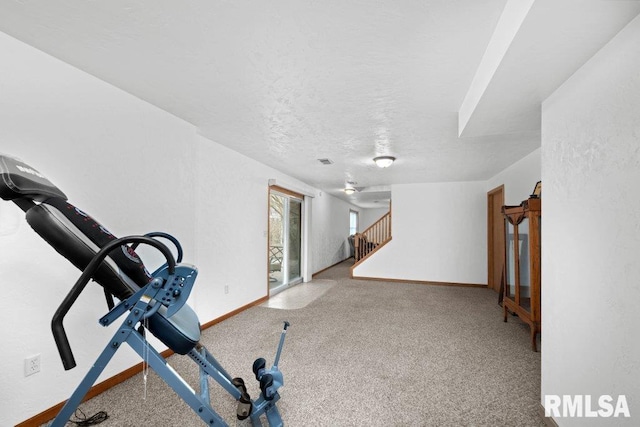 workout area featuring a textured ceiling and carpet flooring