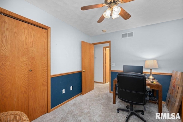 carpeted office space with ceiling fan