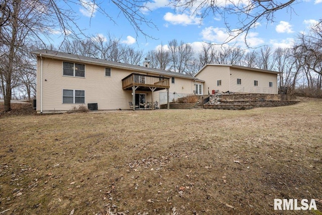 back of house with a wooden deck and a lawn