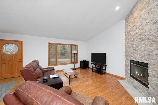 living room featuring hardwood / wood-style floors, a fireplace, and vaulted ceiling