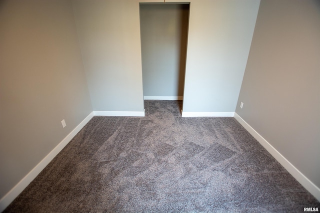 unfurnished bedroom with dark carpet