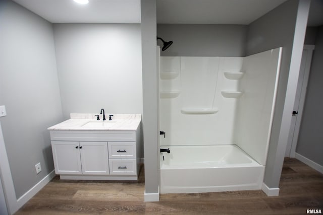 bathroom with wood-type flooring, vanity, and  shower combination