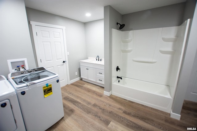 bathroom featuring vanity, washer / clothes dryer,  shower combination, and wood-type flooring