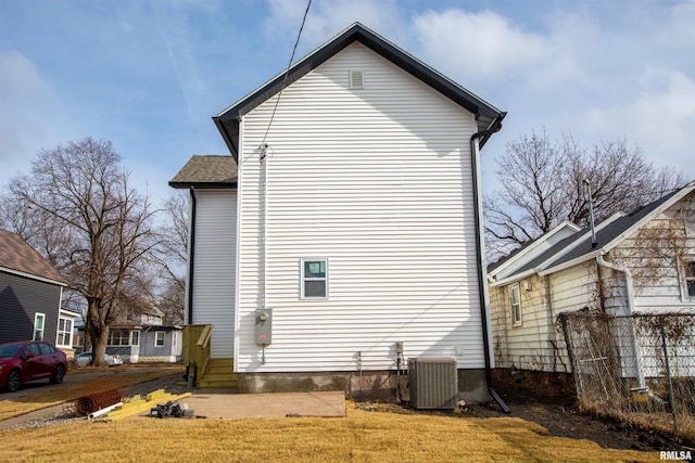 view of side of home featuring a yard and central air condition unit