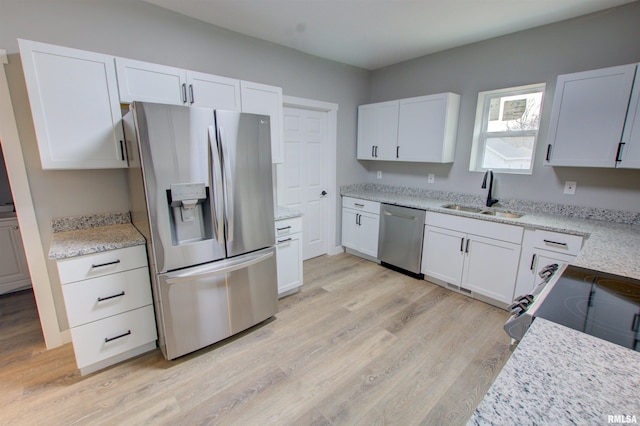 kitchen featuring light wood-type flooring, appliances with stainless steel finishes, sink, and white cabinets