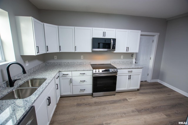 kitchen featuring white cabinetry, sink, light stone countertops, and appliances with stainless steel finishes