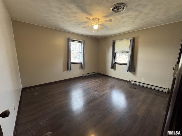 unfurnished room with a baseboard heating unit, dark wood-type flooring, a textured ceiling, and ceiling fan