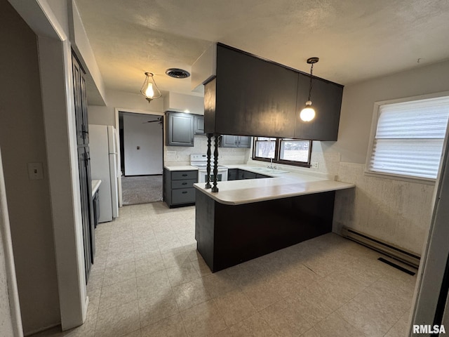 kitchen featuring pendant lighting, sink, white appliances, baseboard heating, and kitchen peninsula