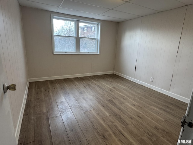 unfurnished room featuring a drop ceiling and hardwood / wood-style floors