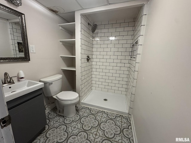 bathroom featuring tile patterned floors, vanity, toilet, and a tile shower