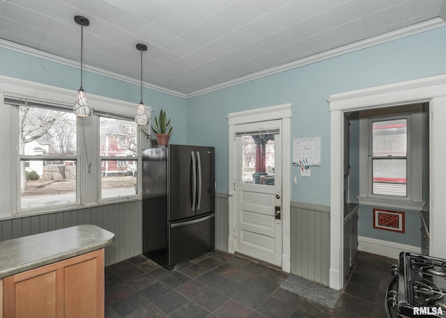 kitchen with black refrigerator, hanging light fixtures, and ornamental molding