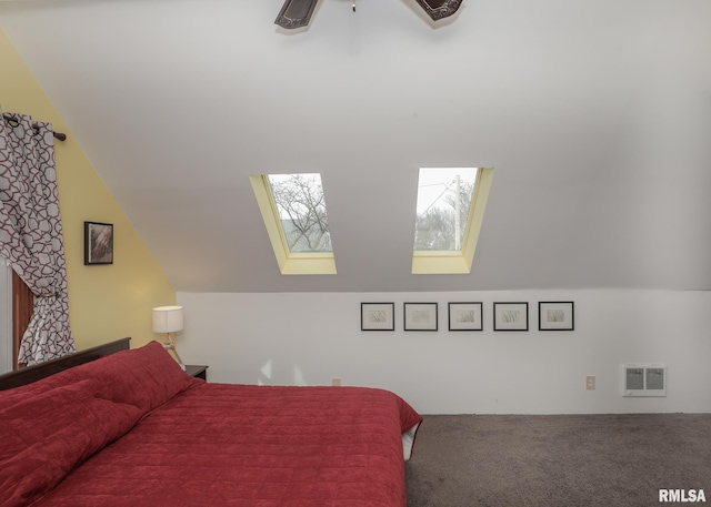 carpeted bedroom with vaulted ceiling with skylight