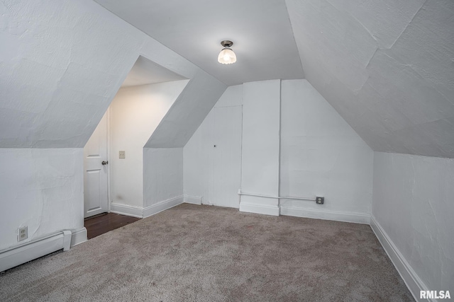 bonus room with dark carpet, a baseboard radiator, and vaulted ceiling