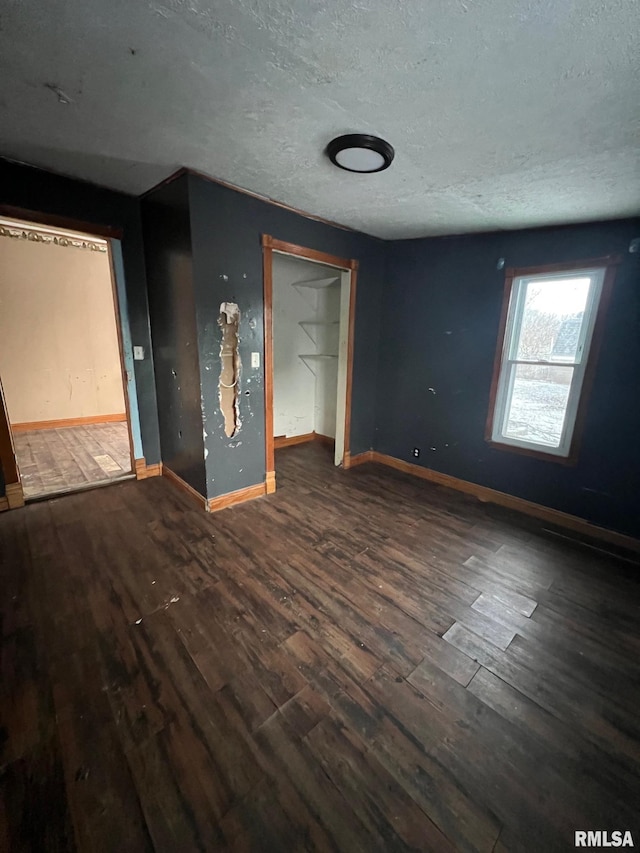 unfurnished bedroom featuring dark wood-type flooring and a textured ceiling