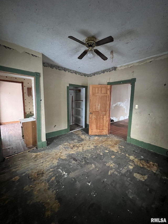 unfurnished bedroom with ceiling fan and a textured ceiling