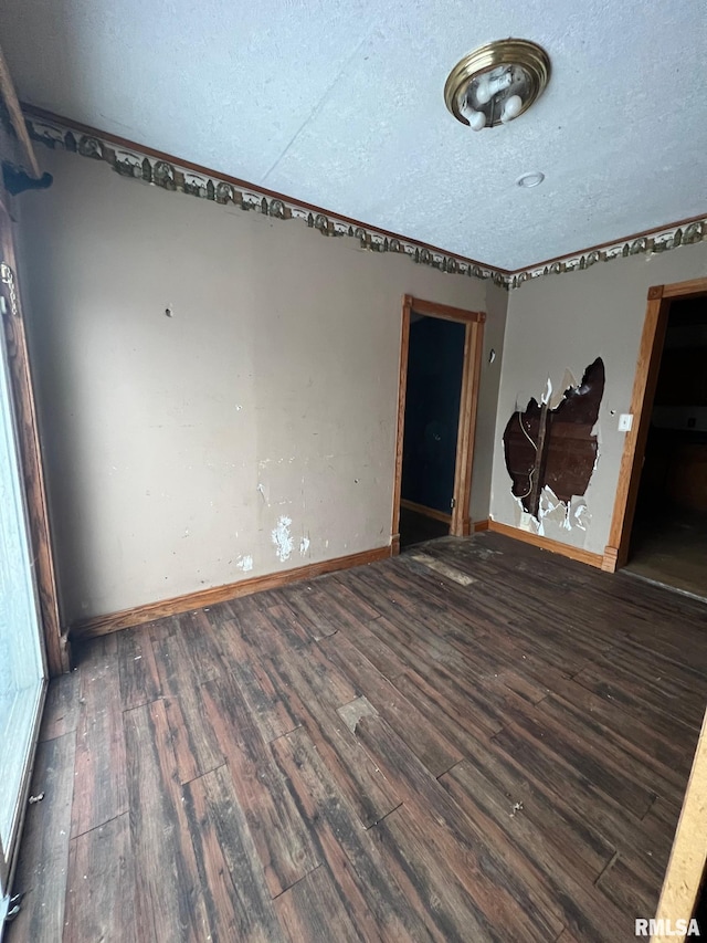 spare room with dark hardwood / wood-style floors and a textured ceiling