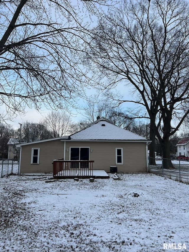 snow covered rear of property with a wooden deck