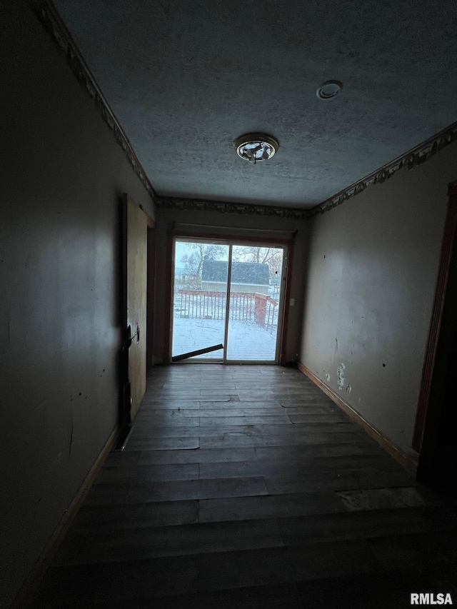 corridor featuring wood-type flooring and a textured ceiling