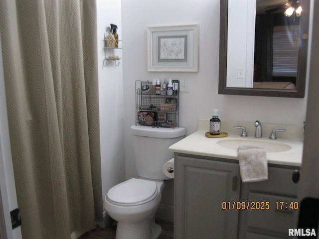 bathroom featuring vanity, curtained shower, and toilet