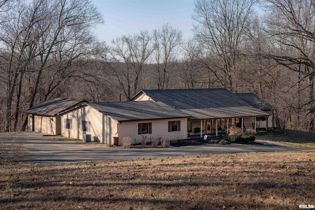 view of front of home with central AC unit and a front lawn