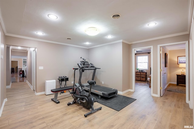 workout room featuring ornamental molding and light hardwood / wood-style flooring