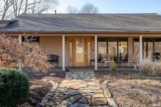 view of exterior entry featuring covered porch