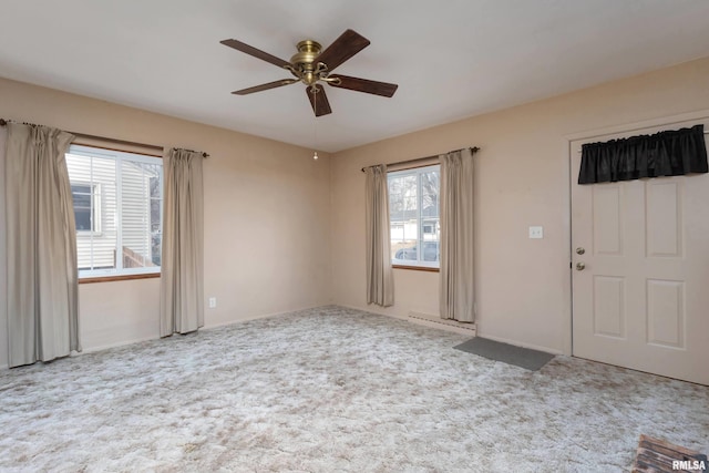 spare room featuring a baseboard heating unit, light colored carpet, and ceiling fan