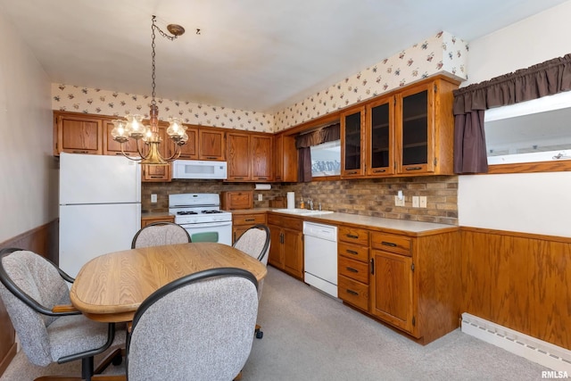 kitchen with sink, an inviting chandelier, hanging light fixtures, baseboard heating, and white appliances