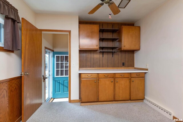 kitchen with a baseboard heating unit, light colored carpet, and ceiling fan