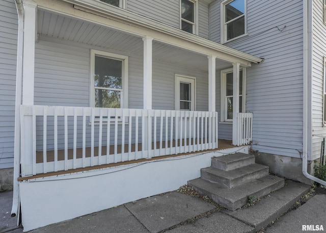 view of exterior entry featuring covered porch