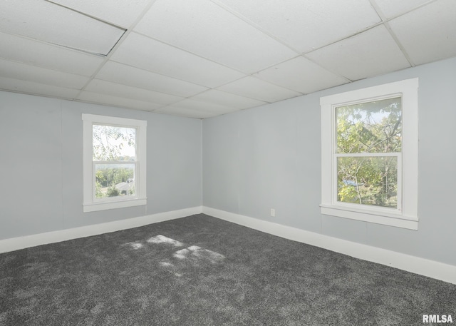 carpeted empty room with a drop ceiling