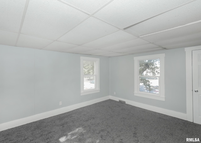 spare room featuring a drop ceiling and carpet flooring