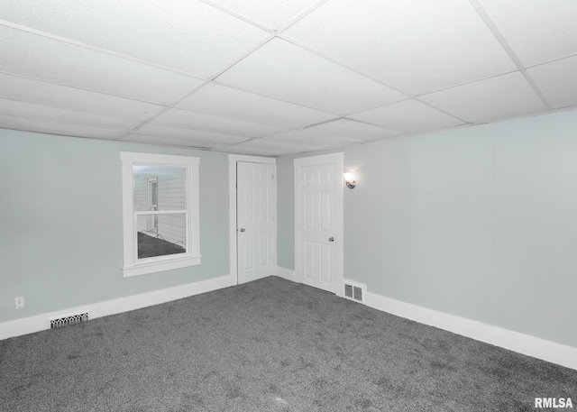 spare room featuring carpet floors and a paneled ceiling