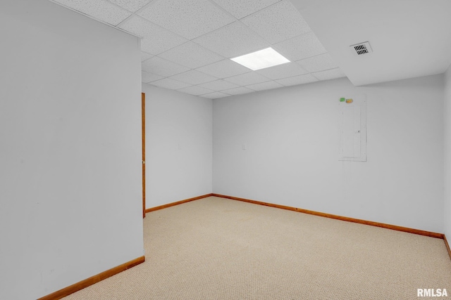 unfurnished room featuring a paneled ceiling, electric panel, and carpet floors