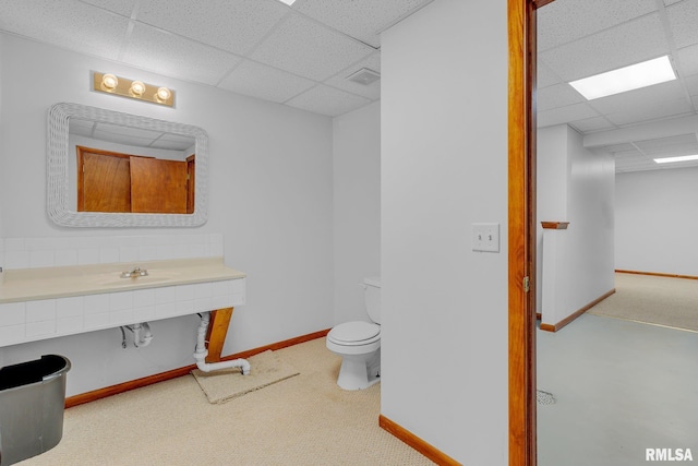 bathroom with sink, a drop ceiling, and toilet