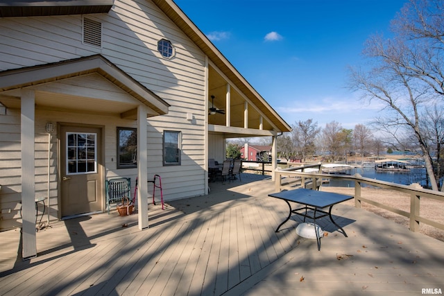 wooden deck with a water view and ceiling fan