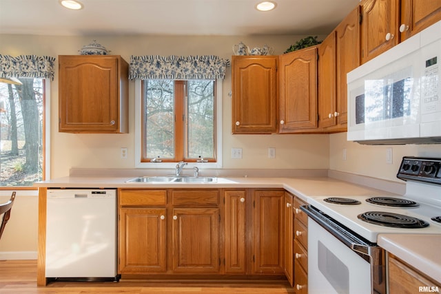 kitchen with sink, white appliances, and light wood-type flooring