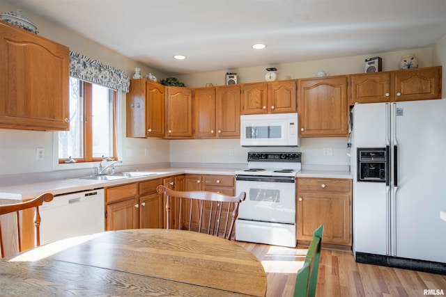 kitchen featuring sink, white appliances, and light hardwood / wood-style floors