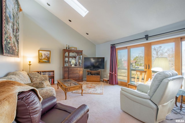 living room with light carpet, a skylight, and high vaulted ceiling