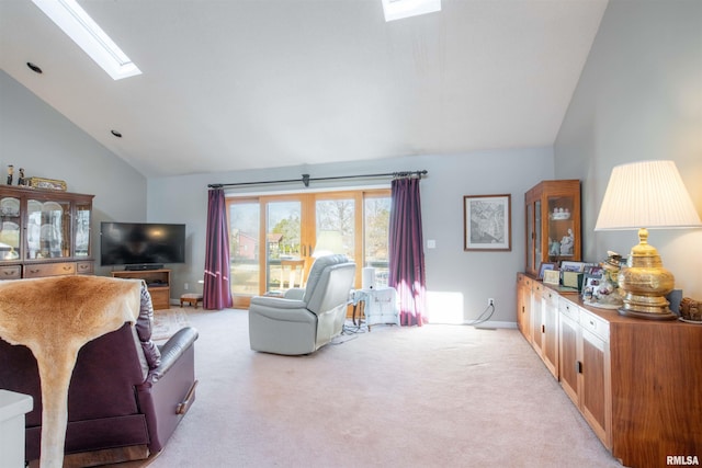 living room with light colored carpet, a skylight, and high vaulted ceiling