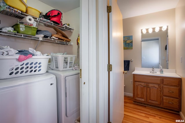 washroom featuring washer and dryer, sink, and light hardwood / wood-style floors