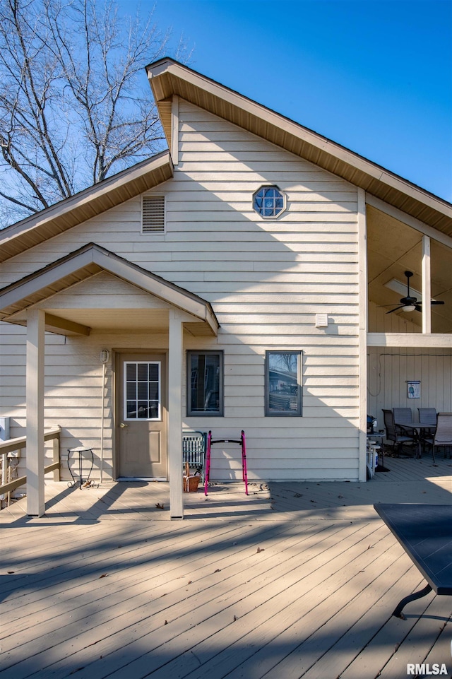 rear view of house featuring a wooden deck and ceiling fan